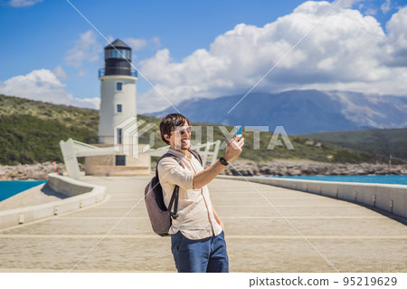 Man tourist enjoying the views of Architecture and luxury yachts in Lustica Bay, Montenegro. Travel around Montenegro concept. Go Everywhere 95219629