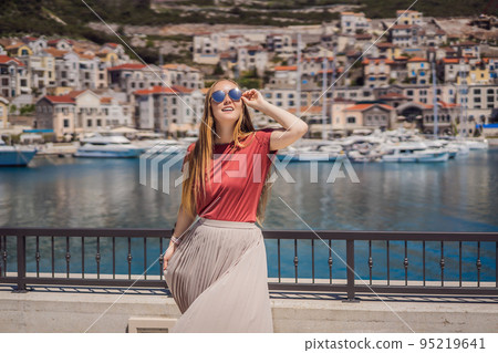 Woman tourist enjoying the views of Architecture and luxury yachts in Lustica Bay, Montenegro. Travel around Montenegro concept. Go Everywhere 95219641