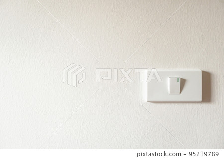light switch on white concrete wall 95219789