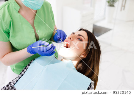 Dentist doing dental checkup for his patient. Dentist doing dental checkup for his patient. 95220140