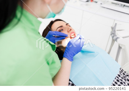Dentist doing dental checkup for his patient. 95220141