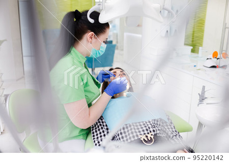 Dentist doing dental checkup for his patient. Dentist doing dental checkup for his patient. 95220142