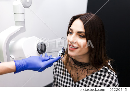 Dentist makes x-ray of the dental cavity for the patient in clinic. 95220545