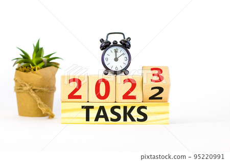 2023 tasks new year symbol. Turned wooden cube and changes words Tasks 2022 to Tasks 2023. Black alarm clock. Beautiful white table white background, copy space. Business 2023 tasks new year concept. 2023 tasks new year symbol. Turned wooden cube and changes words Tasks 2022 to Tasks 2023. Black alarm clock. Beautiful white table white background, copy space. Business 2023 tasks new year concept. 95220991