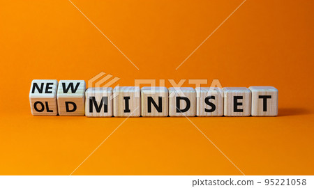 New vs old mindset symbol. Turned wooden cubes and changed words 'old mindset' to 'new mindset'. Beautiful orange background. Business, new or old mindset concept. Copy space. New vs old mindset symbol. Turned wooden cubes and changed words 'old mindset' to 'new mindset'. Beautiful orange background. Business, new or old mindset concept. Copy space. 95221058