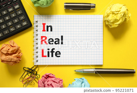 IRL in real life symbol. Concept words IRL in real life on white paper on white note on a beautiful yellow background. Black calculator and pen. Business and IRL in real life concept. Copy space. 95221071