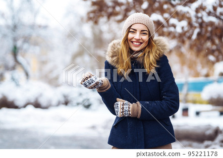 Beautiful woman stands among snowy trees in winter forest. Fashion woman in the winter park. Beautiful woman stands among snowy trees in winter forest. Fashion woman in the winter park. 95221178