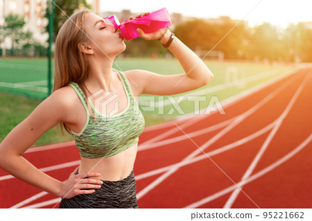 Tired runner drinks water from a bottle 95221662