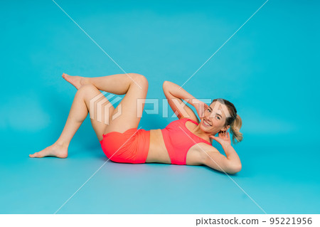 Full length portrait of smiling young woman in sportswear isolated over studio background. Full length portrait of smiling young woman in sportswear isolated over studio background. 95221956