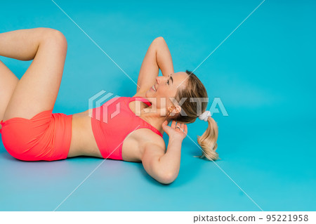 Full length portrait of smiling young woman in sportswear isolated over studio background. Full length portrait of smiling young woman in sportswear isolated over studio background. 95221958