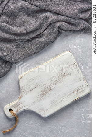 Wooden white cutting room and gray kitchen towel on a light gray concrete table Wooden white cutting room and gray kitchen towel on a light gray concrete table 95222631