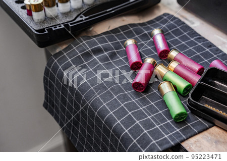 Shotgun shells on wooden table in a workshop 95223471