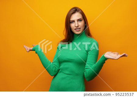 Portrait of cute attractive young woman showing whatever gesture on yellow background Portrait of cute attractive young woman showing whatever gesture on yellow background 95223537