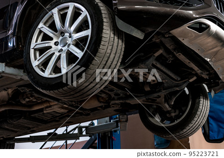 Сar in a car repair service lifted on a jack, view from the bottom 95223721
