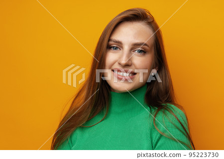 Pretty young woman smiling over yellow isolated background Pretty young woman smiling over yellow isolated background 95223730