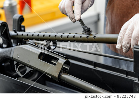 The gunsmith maintaining his rifle in a workshop The gunsmith maintaining his rifle in a workshop 95223748