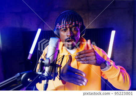 Young African performer recording his new track in recording studio 95223801