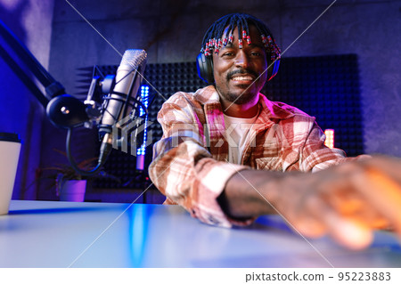 Happy young african man audio blogger broadcasting at studio Happy young african man audio blogger broadcasting at studio 95223883