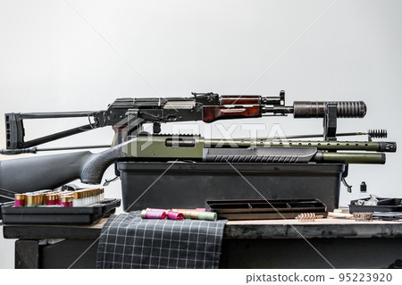 Shotgun rifle with cartridges on table in a weapon workshop 95223920