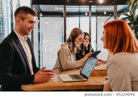 A group of friends hanging out in a cafe, and among them is a tablet. 95224049