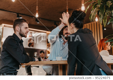 A group of friends hanging out in a cafe, and among them is a tablet. 95224075