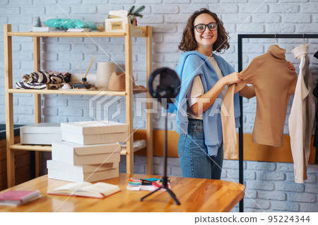 Female warehouse worker, seller, dropshipping small business owner recording new content for vlog. Female warehouse worker, seller, dropshipping small business owner recording new content for vlog. 95224344