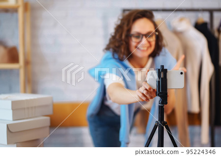 Female warehouse worker, seller, dropshipping small business owner recording new content for vlog. Female warehouse worker, seller, dropshipping small business owner recording new content for vlog. 95224346