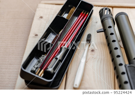Disassembled rifle with cleaning tools on table of weapons workshop 95224424