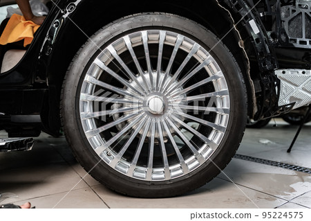 Close up view of a wheel of luxury car. Close up view of a wheel of luxury car. 95224575
