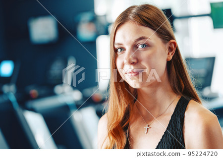 Smiling teen girl training in a fitness club Smiling teen girl training in a fitness club 95224720