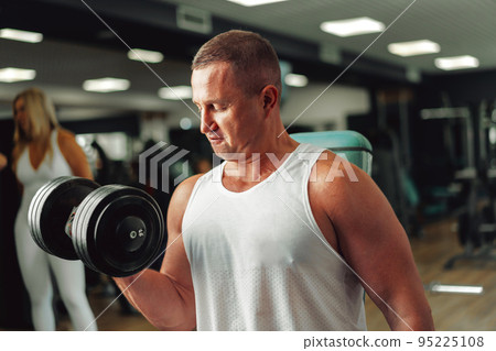 Middle-aged fit muscular man training in a sports gym 95225108