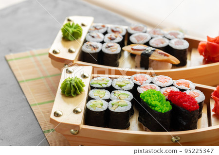 Set of maki sushi on wooden boat tray Set of maki sushi on wooden boat tray 95225347