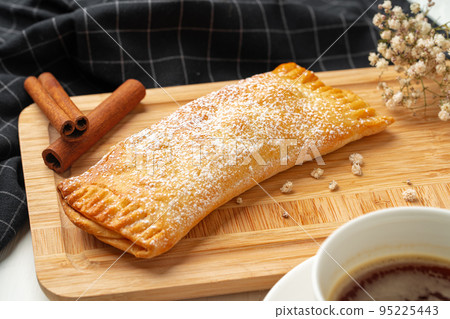 Traditional apple strudel on wooden board, close up Traditional apple strudel on wooden board, close up 95225443
