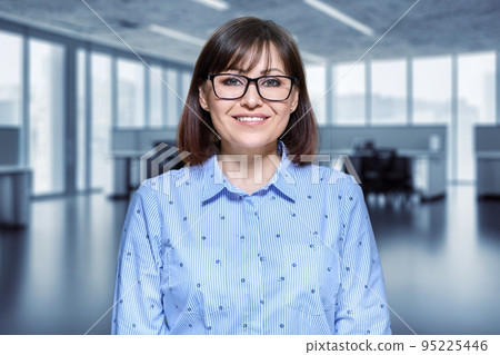 Portrait of mature business woman looking at camera in office interior Portrait of mature business woman looking at camera in office interior 95225446