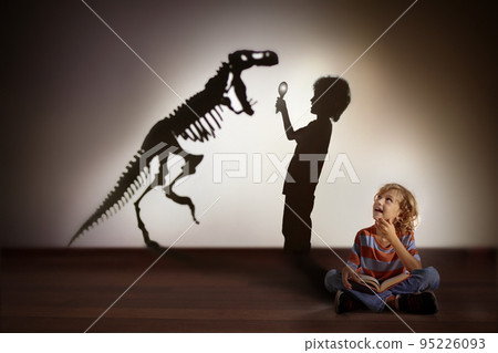 Dinosaur shadow in child dream. Kids read, imagine Dinosaur shadow in child dream. Kids read, imagine 95226093