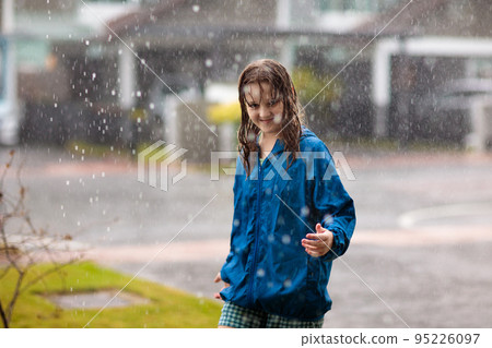 Kids play in rain. Children walk in rainy weather Kids play in rain. Children walk in rainy weather 95226097