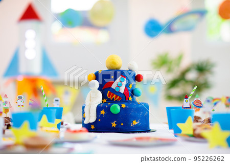 Kids space theme birthday party with cake. 95226262