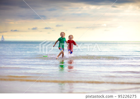 Kids play on tropical beach. Sand and water toy. 95226275