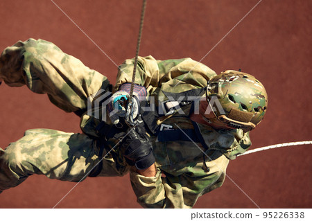 Special forces fighter descends from a skyscraper to storm the apartment. Police, counter terrorism concept. Mixed media 95226338