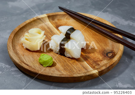 Japanese traditional sushi with squid on a black background. Authentic Japanese food. Japanese traditional sushi with squid on a black background. Authentic Japanese food. 95226403