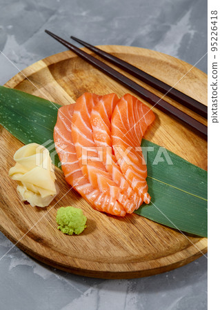 Japanese food style, Top view of salmon slice on bamboo leaves, Salmon sashimi is Japanese traditional, Selective focus, Fish slices top view Japanese food style, Top view of salmon slice on bamboo leaves, Salmon sashimi is Japanese traditional, Selective focus, Fish slices top view 95226418