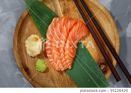 Japanese food style, Top view of salmon slice on bamboo leaves, Salmon sashimi is Japanese traditional, Selective focus, Fish slices top view Japanese food style, Top view of salmon slice on bamboo leaves, Salmon sashimi is Japanese traditional, Selective focus, Fish slices top view 95226420