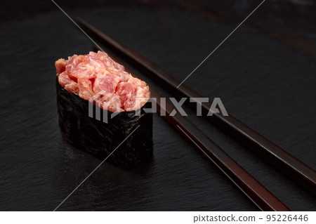Warm rolls with tuna, salmon, perch, eel, tobiko caviar, nori, rice, cucumber on black background. Warm rolls with tuna, salmon, perch, eel, tobiko caviar, nori, rice, cucumber on black background. 95226446