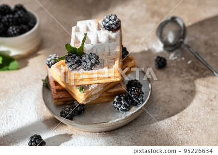 Stack of homemade belgium waffles close up with blackberry and powdered sugar on the kitchen table. Morning breakfast concept 95226634