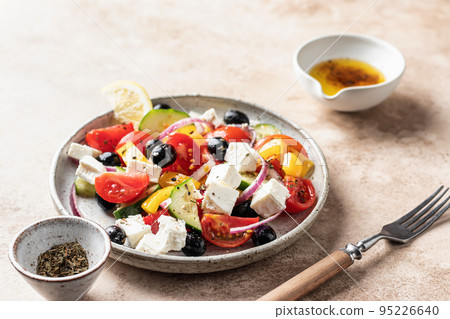 Traditional greek salad with feta cheese, tomatoes, red onion, cucumber, pepper, olive oil and italian herbs served on beige background with rustic fork Traditional greek salad with feta cheese, tomatoes, red onion, cucumber, pepper, olive oil and italian herbs served on beige background with rustic fork 95226640
