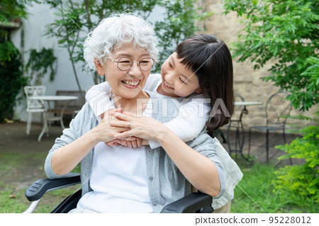Senior woman in wheelchair and granddaughter girl 95228012