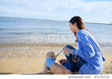 女人和她的狗在沙灘上玩耍 女人和她的狗在沙灘上玩耍 95230129