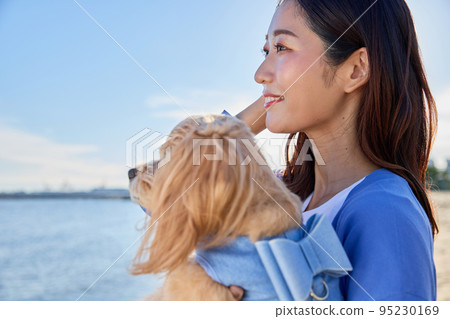Woman playing on the beach with her dog Woman playing on the beach with her dog 95230169