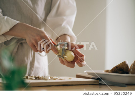 女人在廚房裡剝土豆 95230249