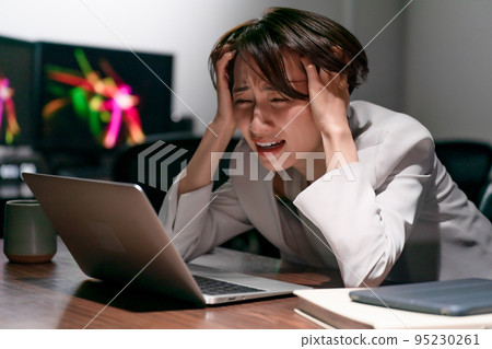 Business woman holding her head overtime 95230261
